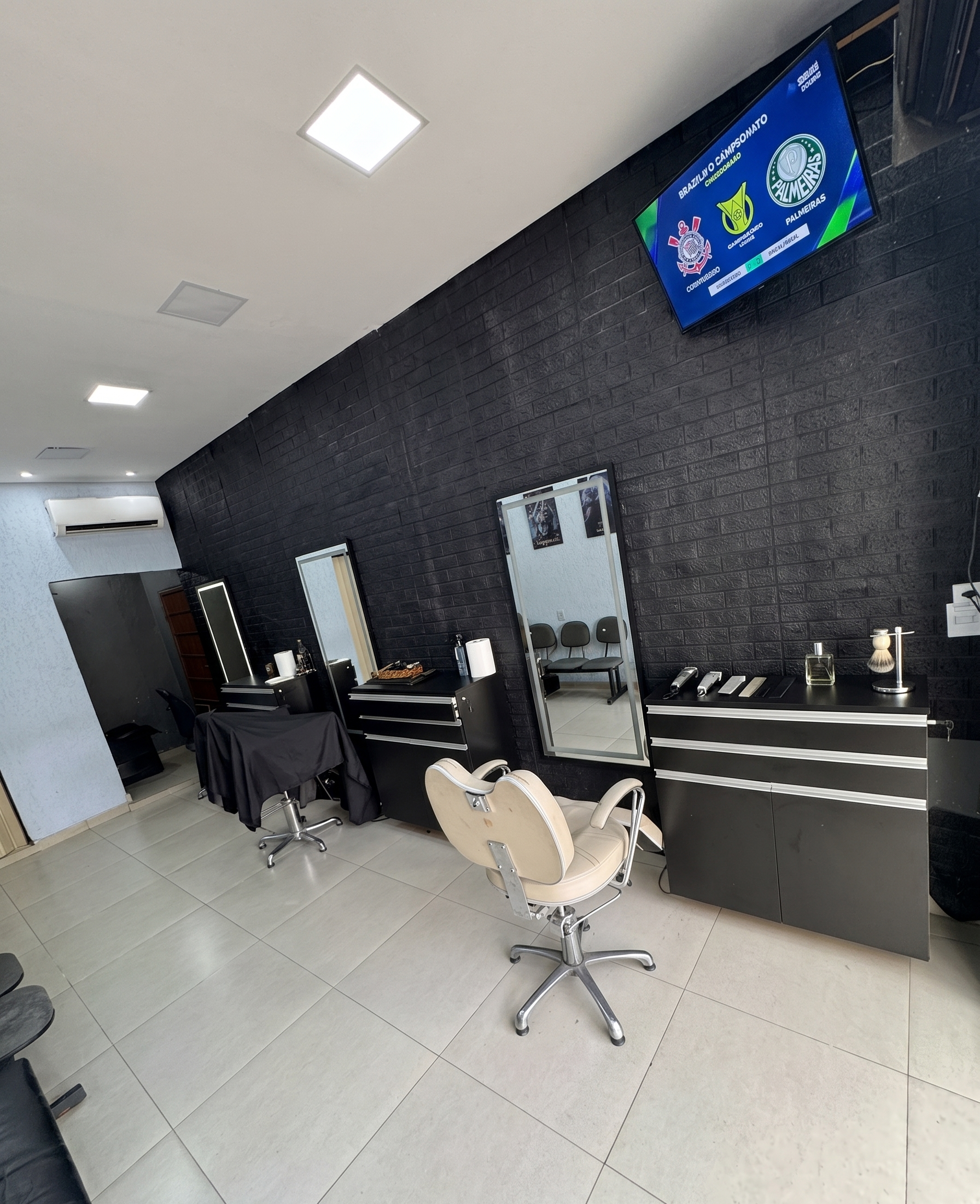 Interior da barbearia Coruja do Corte com cadeiras profissionais
